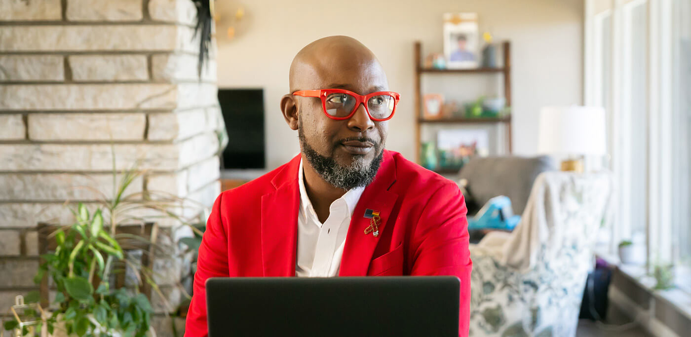 Black man looking away from laptop