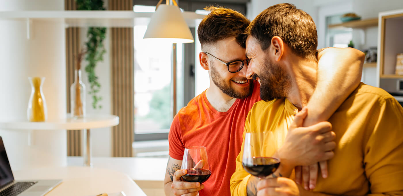 A couple hugging and drinking red wine