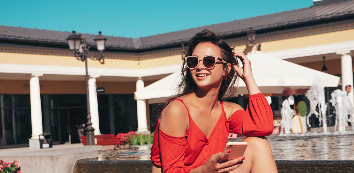 Women on phone wearing red by the pool